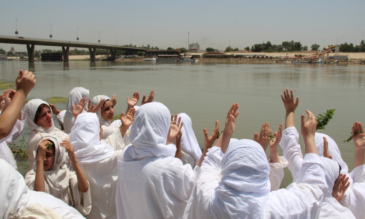 مندائيون بملابسهم البيضاء يتعمّدون في نهر دجلة (العراق). © Uday Khamas
