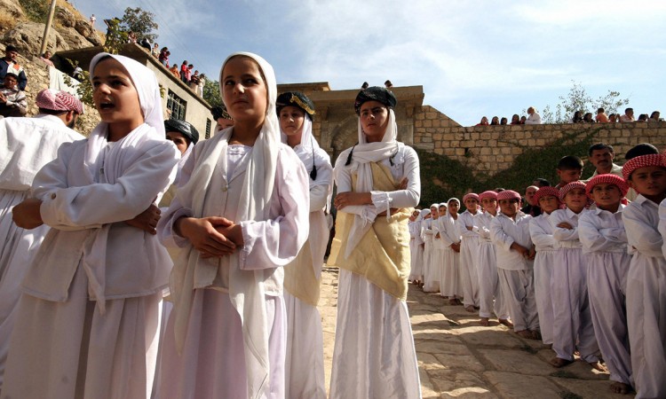 صبيان وبنات أيزيديّون ينشدون أغانٍ دينيّة في معبد لالش (العراق). - AFP ©