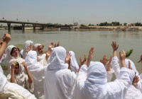 مندائيون بملابسهم البيضاء يتعمّدون في نهر دجلة (العراق). © Uday Khamas